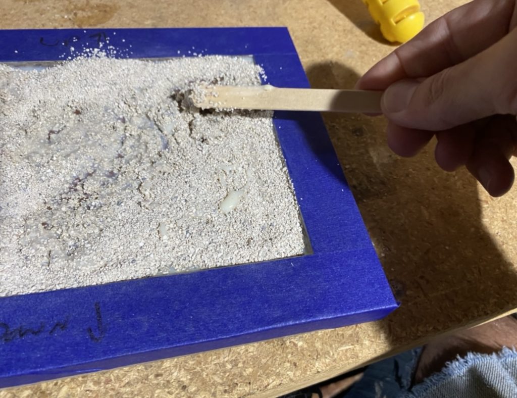 Spread sand with a popsicle stick