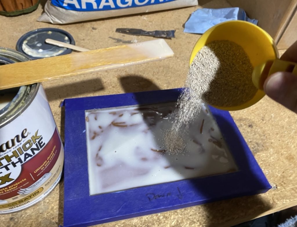 Pour sand over the polyurethane