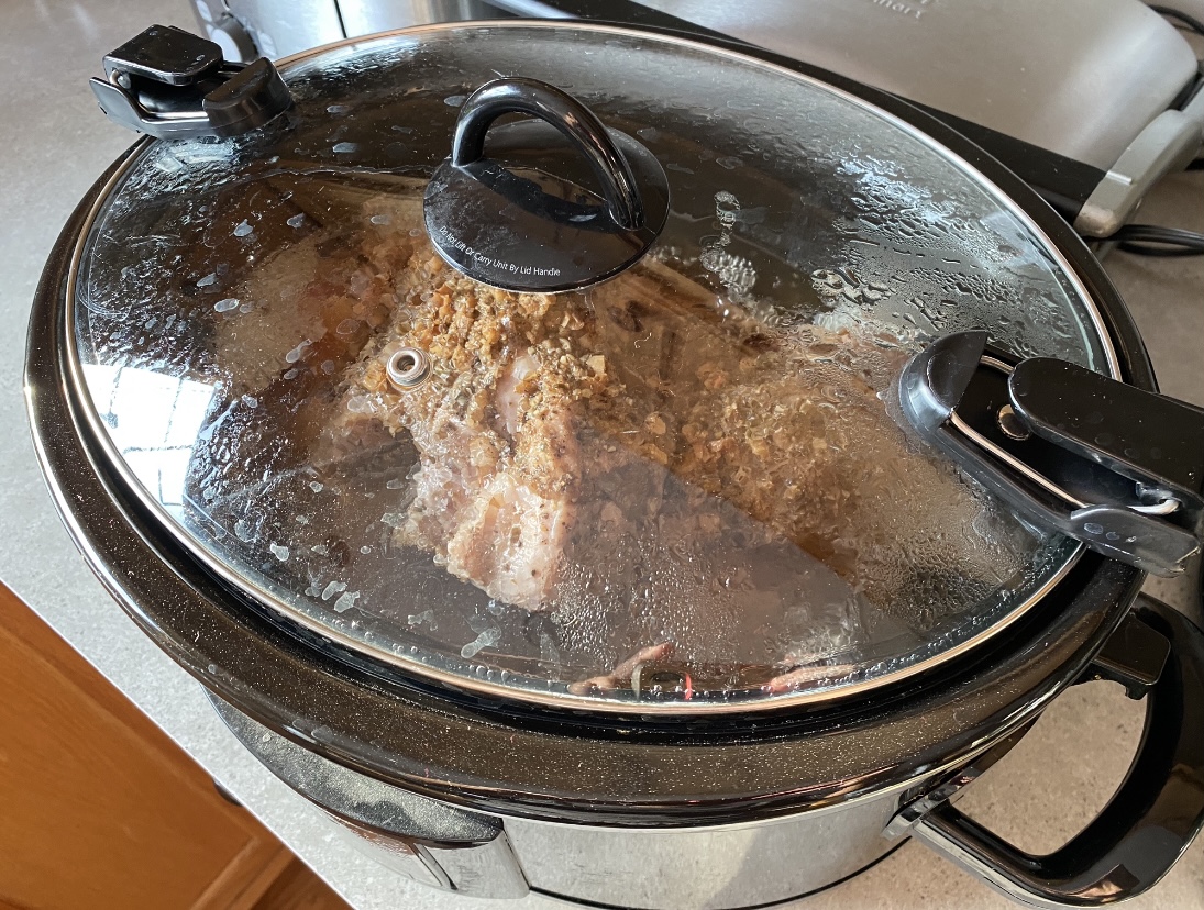 Pork roast cooking in a crock pot for pulled pork
